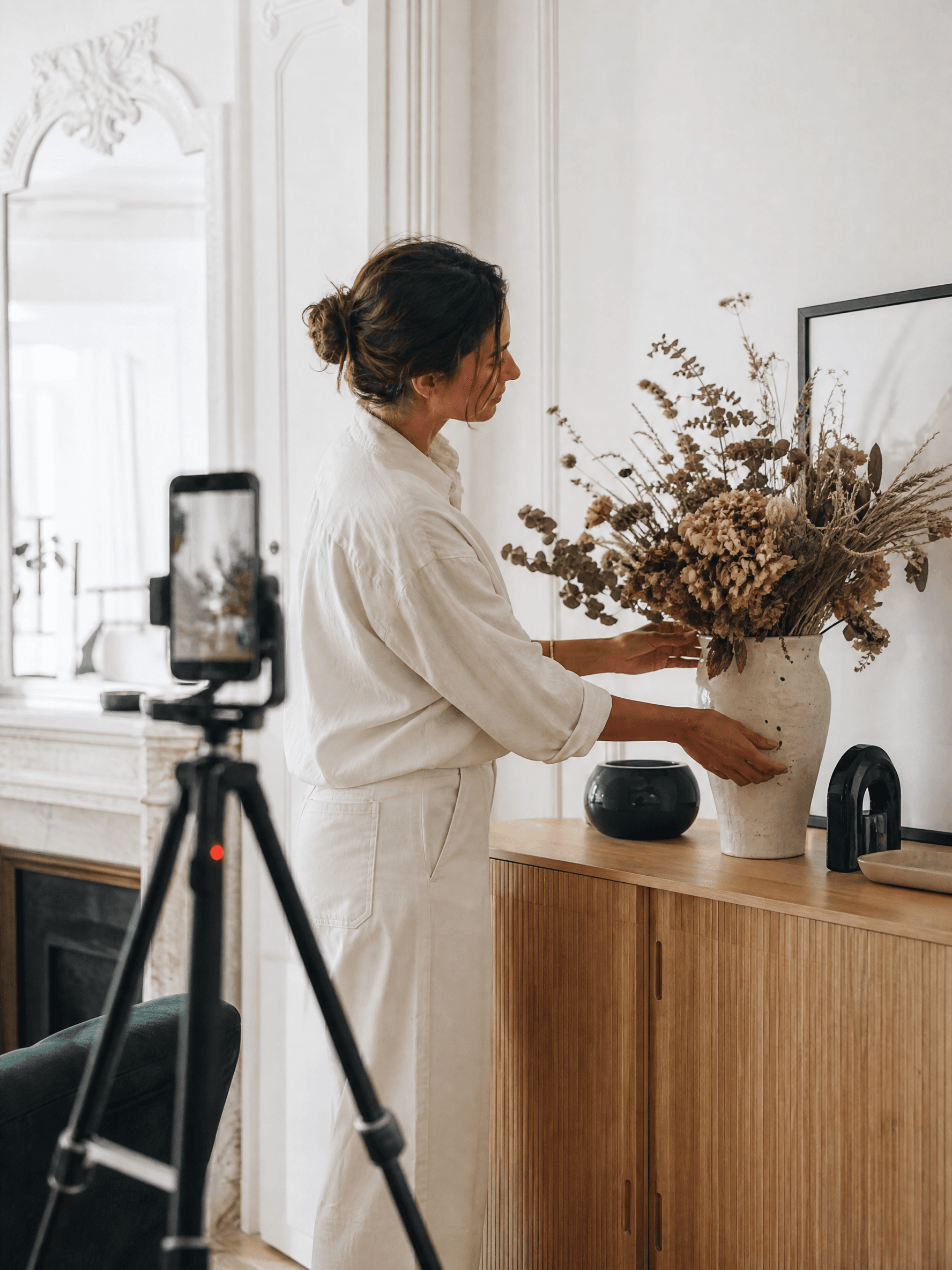 Créatrice déco qui compose un bouquet de fleurs séchées dans son salon